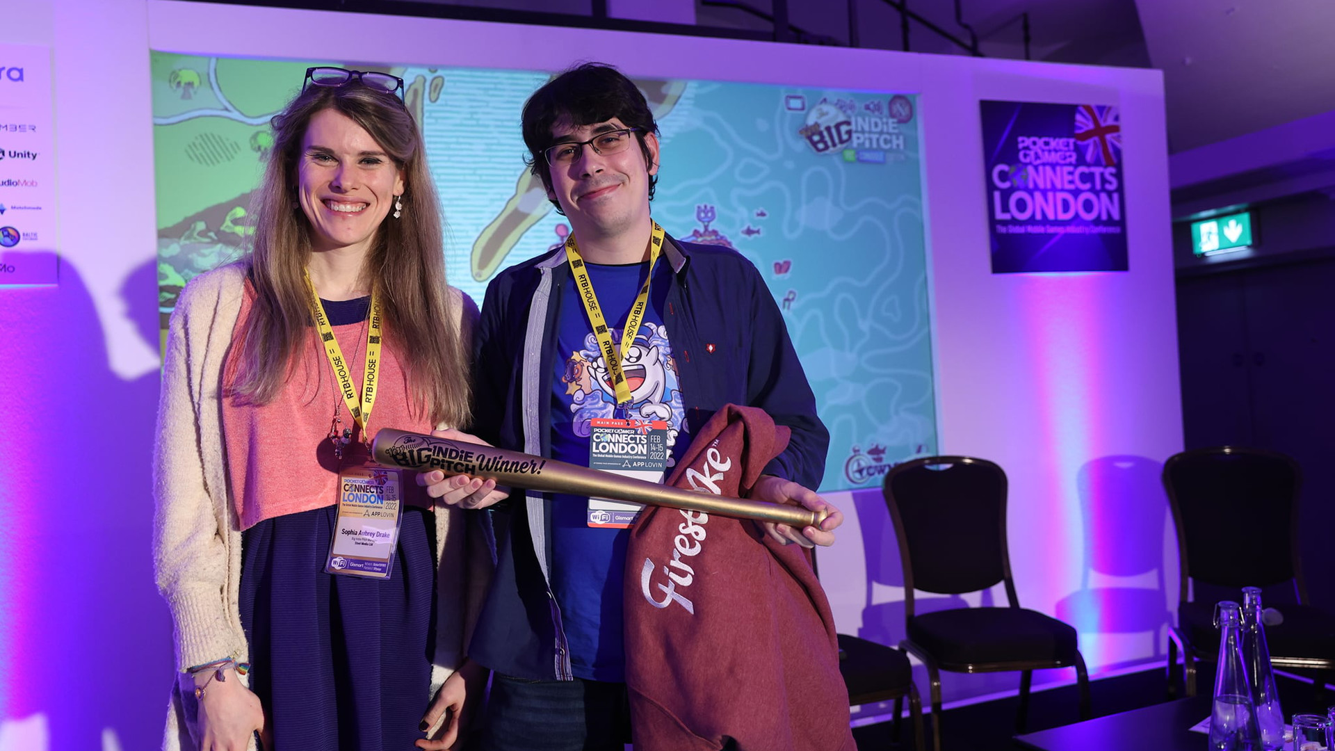 Photo of Jorge receiving the Big Indie Pitch Golden Bat awarded by Sophia Aubrey Drake at PocketGamer Connects London 2022
